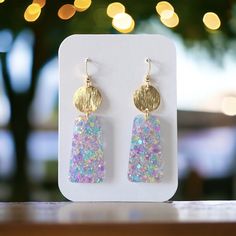 Confetti Glitter Earrings, Available in two captivating styles, these earrings feature a stunning trapezoid design adorned with an enchanting array of confetti glitter, meticulously arranged to catch and reflect light in a dazzling display of sparkles. Measuring 2.50 inches from the hook and 0.75 inches in width. With hypoallergenic findings, they ensure comfort and confidence for wearers with sensitive ears. Atop the trapezoid silhouette sits a sleek brass disc, adding a touch of refinement to the ensemble. creating a harmonious balance between sophistication and playfulness. Earrings come in a gift bag with a polishing cloth:) safely packaged in a shipping box.  Please contact me with any questions. Glitter Earrings, Party Earrings, Lightweight Earrings, Light Weight Earrings, Sensitive Ears, Leather Earrings, Resin Jewelry, Earring Gifts, Confetti