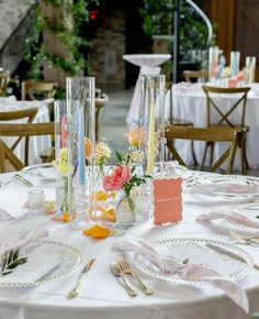 the table is set with flowers and place settings