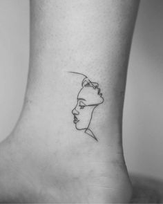 a woman's foot with a single line drawing of a face on the side