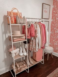 a closet with clothes, shoes and handbags hanging on the rack in front of it