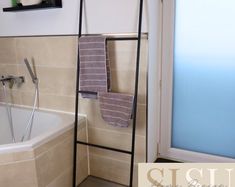 a towel rack in the corner of a bathroom next to a bathtub and shower