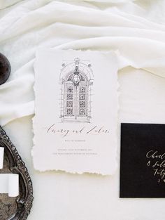 the wedding stationery is laid out on top of an antique mirror and other items