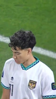 a young man standing on top of a soccer field