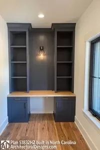 an empty room with built in desk and bookcases