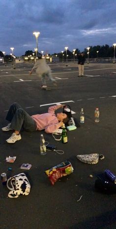 a man laying on the ground with his head down and other items scattered around him