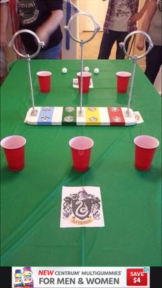 a green table topped with red cups and cards