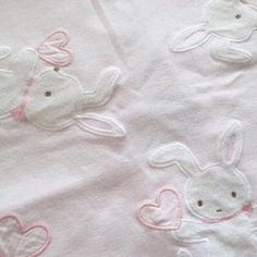 a white blanket with pink hearts and rabbits on it