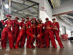 a group of women in red outfits standing next to each other