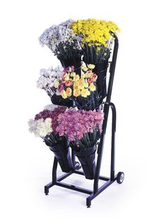 a cart with flowers on it is holding several different types of flowers and the wheels are black