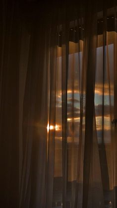 the sun is shining through sheer curtains