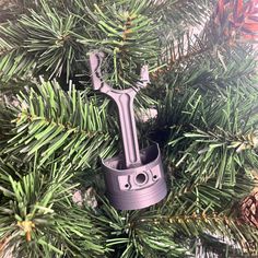 an ornament in the shape of a camera hanging from a christmas tree branch