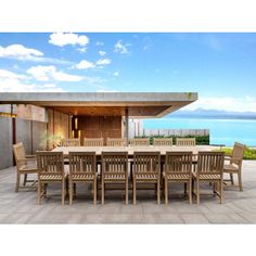 an outdoor dining table and chairs with the ocean in the background