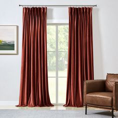 a living room with a brown chair and red curtains