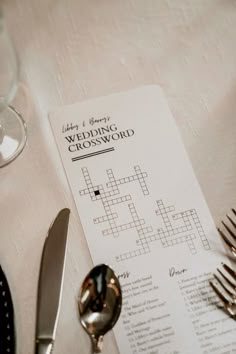 a table topped with silverware and a crossword menu