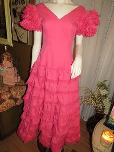 "Maybe 60's/70's lovely pink ruffle-listic dress, ankle-length, by Creaciones, in a size 7/C. Great Quinceanera celebration wear, with V-neck-off shouldered fitted bodice, huge ruffled 4 layered sleeves, and the skirt part is tapered at the waist, with and 8 layered ruffled skirt. The dress has a nylon back zipper closure, and in photo 6 & 7, is not zipped all the way to the top/back, because my mannequin is a slight too large for it. Dress is of cotton fabric, and is a little weighty from s Spring Party Vintage Dress With Ruffles, Spring Vintage Dress With Ruffles For Parties, Pink Vintage Dress For Summer Party, Vintage Party Dress With Ruffle Hem, Retro Pink Dresses With Ruffles, Retro Pink Ruffled Dresses, Pink Retro Dresses With Ruffles, Pink Retro Dress With Ruffles, Fitted Pink Vintage Dress For Spring