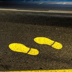 two yellow footprints are painted on the road