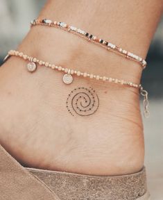 a close up of a person's foot with a tattoo on the side of her ankle