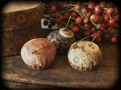 three decorative vases sitting on top of a wooden table next to berries and other items