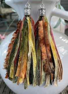 These vibrant tassel earrings will add the perfect pop of color to your wardrobe whether you're wearing a simple t-shirt and jeans or heading out in your favorite dress!  These fun earrings are made from carefully selected, high quality pieces of beautiful, rare novelty yarns.  The tassel part of the earring measures approximately 3 inches with a total drop length of 4 inches when including the earring end cap.  The end cap has a pretty antique heart pattern and the earring wire is stainless ste Bohemian Brown Earrings For Spring, Multicolor Fringe Tassel Earrings For Spring, Trendy Multicolor Tassel Earrings, Trendy Multicolor Fringe Earrings, Designer Tassels, Unique Gold Rings, Novelty Yarn, Earring Wire, Simple T Shirt