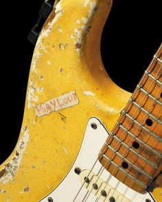 an old yellow electric guitar with the neck missing