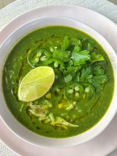 a white bowl filled with green soup and garnish