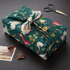 an image of a green bag with animals on it and some other items next to it