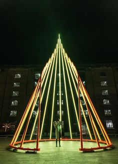 two people standing next to each other in front of a tall building with lights on it