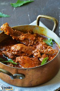 a pot filled with meat and sauce on top of a table