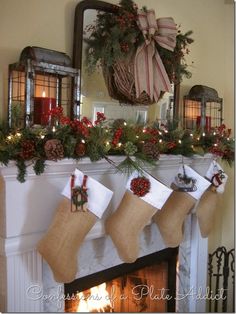 christmas stockings hung on the mantle with candles and decorations