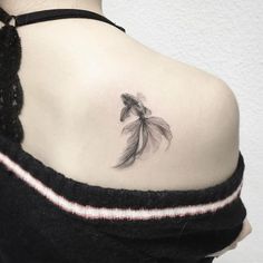 the back of a woman's shoulder with a tattoo on it