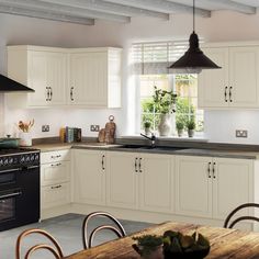 a kitchen with white cabinets and black appliances