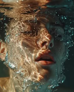 a woman is submerged in the water with her eyes closed