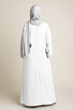 Experience timeless elegance with our Classic Straight Abaya – Halimah in white. This sophisticated piece is crafted from lightweight yet fully opaque fabric, ensuring you look and feel your best. Our thoughtful design includes practical side pockets and wudhu-friendly sleeves, making it a perfect choice for all seasons and occasions. Whether dressing up or down, the Halimah Abaya is an essential modest dress for any woman's wardrobe. Please Note: Although the abaya is lined for added coverage, Straight Abaya, Hijab Colors, Jersey Hijab, Bamboo Shades, Modest Dress, Women's Wardrobe, Modest Dresses, Relaxed Style, Autumn Summer