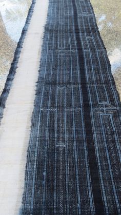 a black and white striped rug sitting on top of a wooden floor