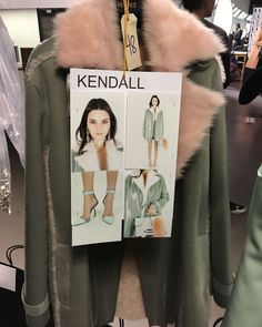 a jacket with fur collars and heels on display in a store window, next to a sign that says kendall