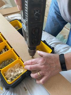 a person is using a drill to cut through the holes in plastic containers with screwdrivers