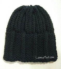 a black knitted beanie hat sitting on top of a white table