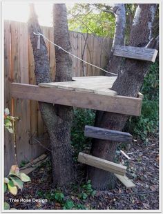 a tree house built into the side of a fence