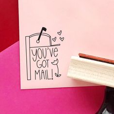 a rubber stamp with the words you've got mail on it next to a pink background