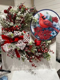 a christmas wreath with a cardinal on it next to a plate