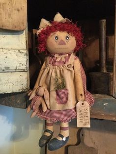 an old fashioned doll with red hair is hanging from the side of a wooden door