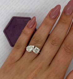 a woman's hand with two engagement rings on it