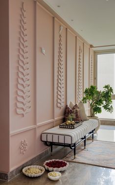 a living room with pink walls and two bowls of food on the floor next to it