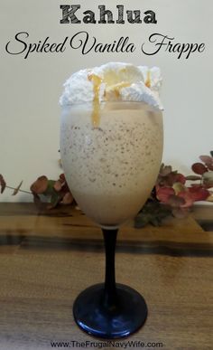 a drink in a wine glass with whipped cream on top