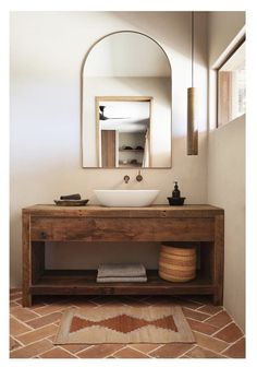 a bathroom with a sink, mirror and rug on the floor in front of it