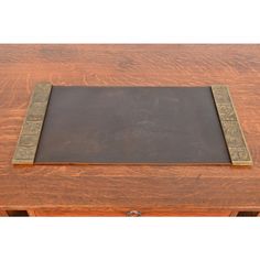 a wooden table with a blackboard on top and gold trimming around the edge