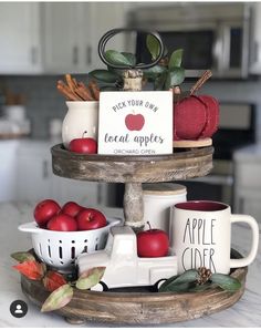 two tiered tray with apples and mugs on it, one has a sign that says pick your day