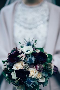 a bridal holding a bouquet of flowers in her hands and wearing a white coat