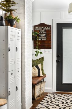 a white locker and black door in a room with a rug on the floor next to it