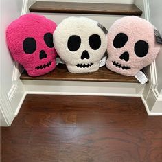 three stuffed skulls sitting on top of a wooden shelf